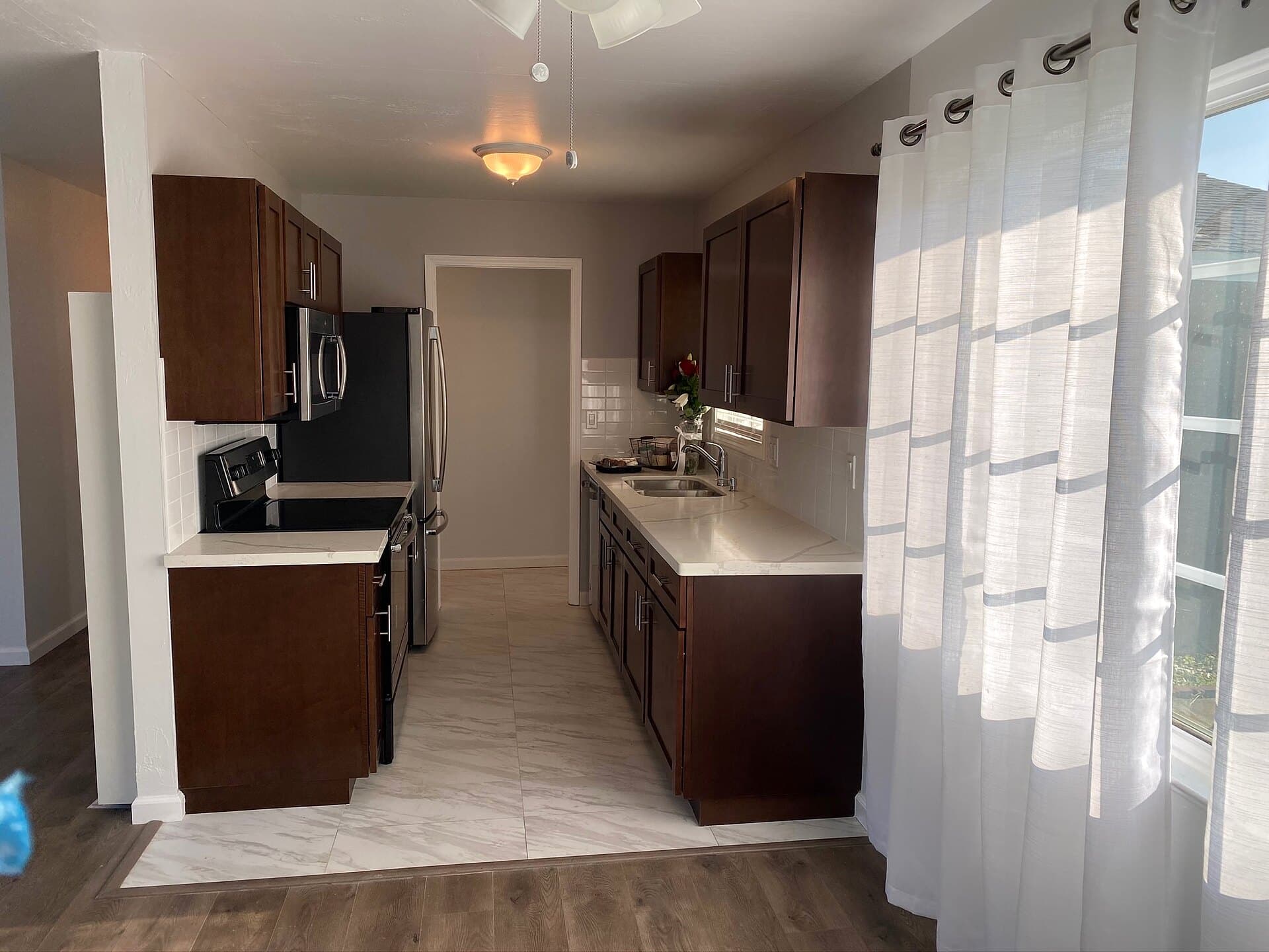 Remodeled galley kitchen with espresso cabinets and quartz counters